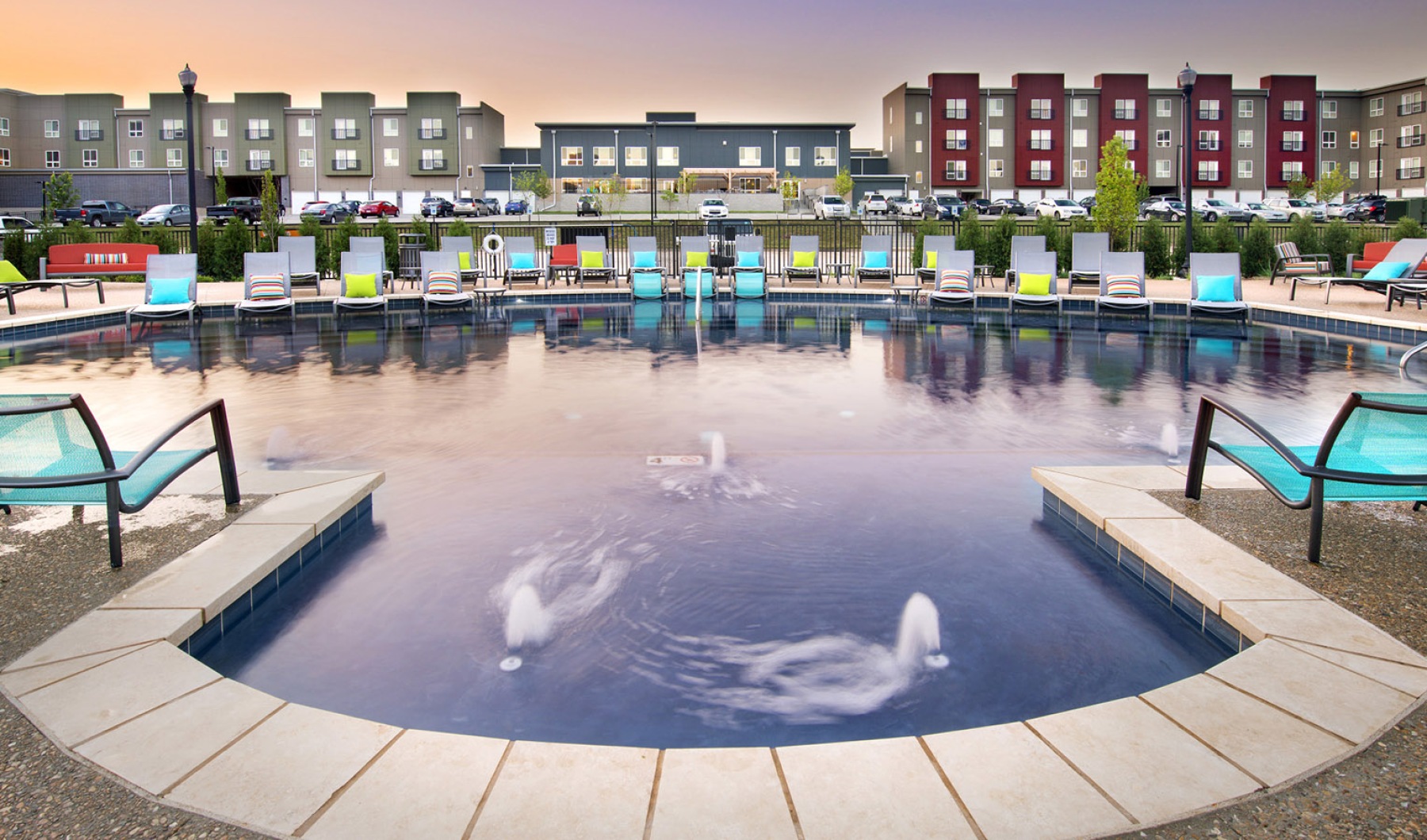 a pool with chairs at dusk